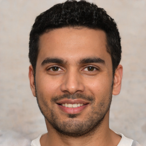 Joyful latino young-adult male with short  black hair and brown eyes