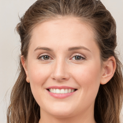 Joyful white young-adult female with long  brown hair and grey eyes