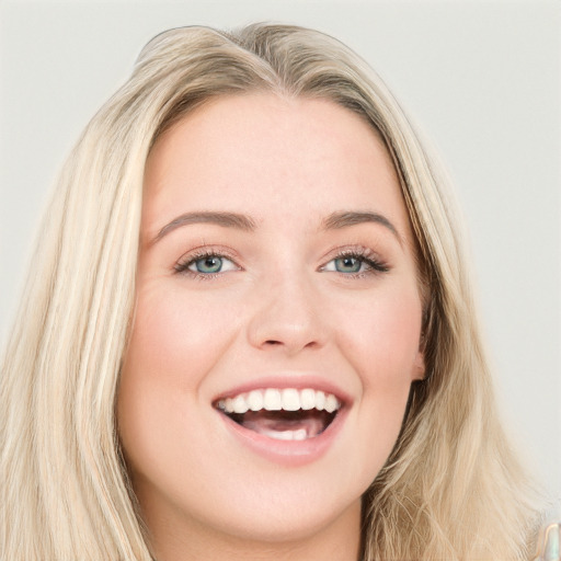 Joyful white young-adult female with long  brown hair and blue eyes