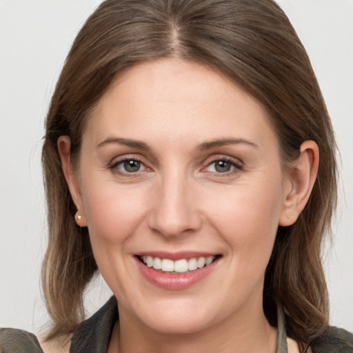 Joyful white young-adult female with medium  brown hair and grey eyes