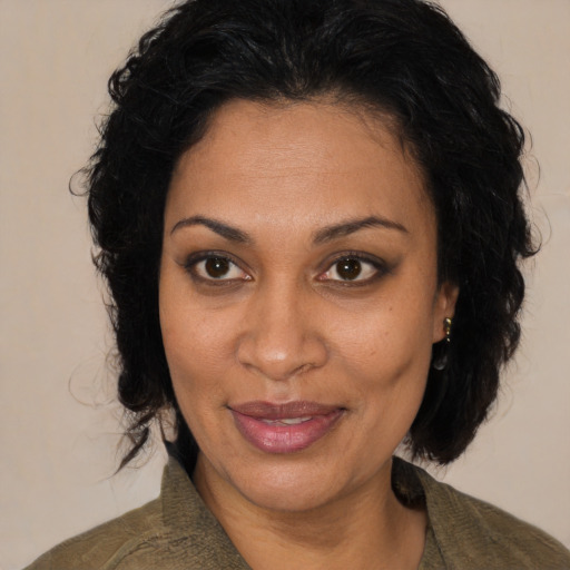 Joyful latino adult female with medium  black hair and brown eyes