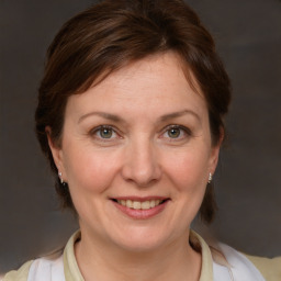 Joyful white adult female with medium  brown hair and blue eyes