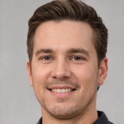 Joyful white adult male with short  brown hair and brown eyes