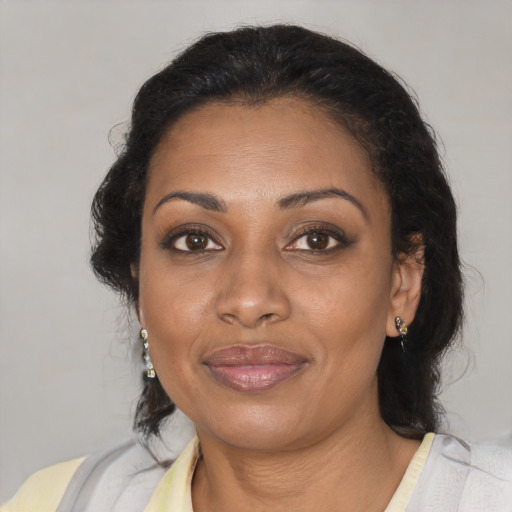 Joyful black adult female with medium  brown hair and brown eyes