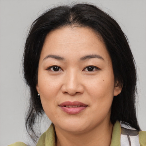 Joyful asian adult female with medium  brown hair and brown eyes