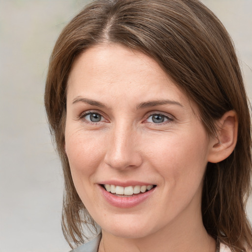 Joyful white young-adult female with medium  brown hair and grey eyes