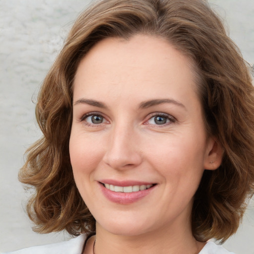 Joyful white young-adult female with medium  brown hair and green eyes