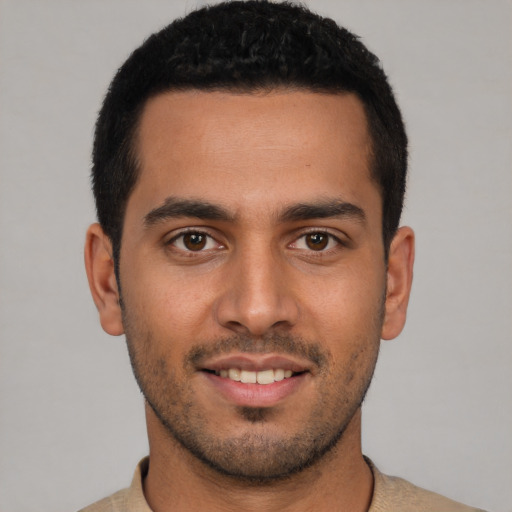 Joyful latino young-adult male with short  brown hair and brown eyes