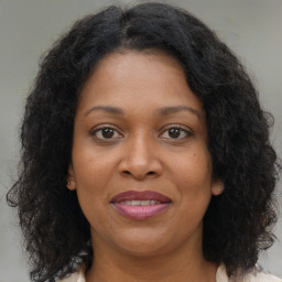 Joyful black adult female with medium  brown hair and brown eyes