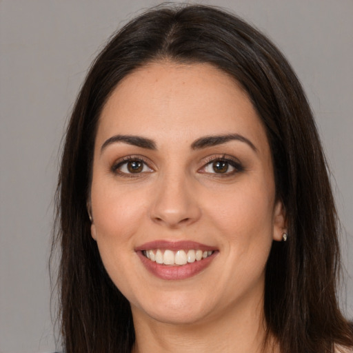 Joyful white young-adult female with long  brown hair and brown eyes