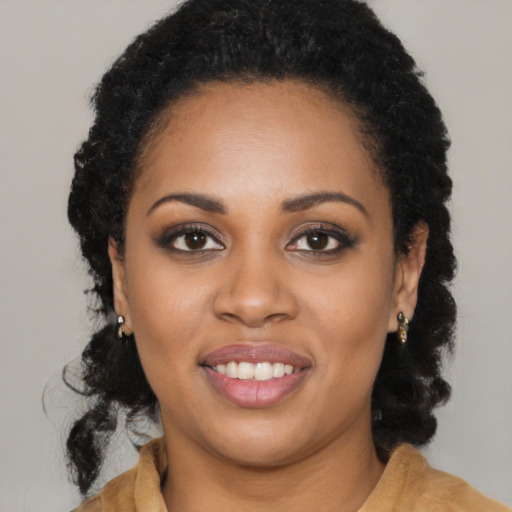 Joyful black young-adult female with long  black hair and brown eyes
