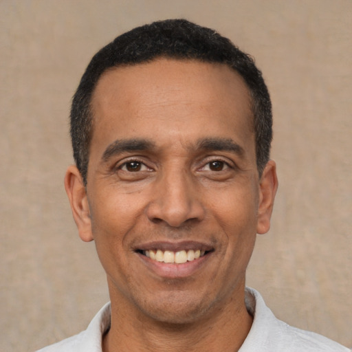 Joyful latino adult male with short  black hair and brown eyes