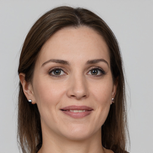 Joyful white young-adult female with long  brown hair and grey eyes