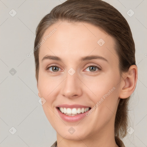 Joyful white young-adult female with medium  brown hair and grey eyes