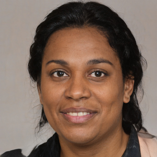 Joyful black adult female with medium  black hair and brown eyes