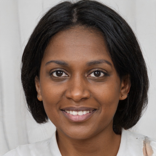 Joyful black young-adult female with medium  brown hair and brown eyes