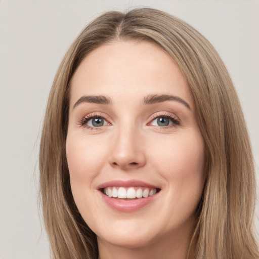 Joyful white young-adult female with long  brown hair and green eyes