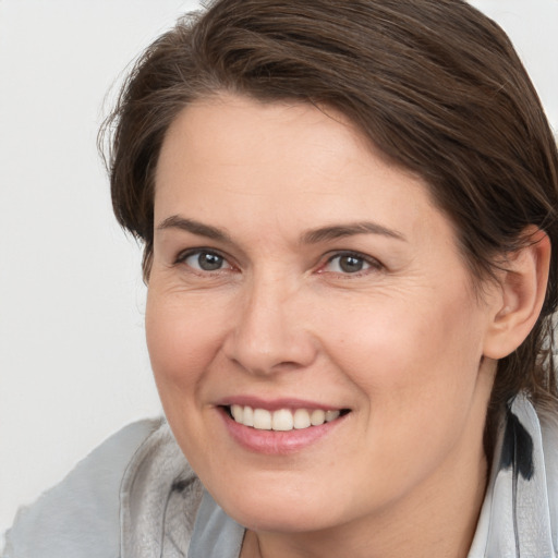 Joyful white adult female with medium  brown hair and brown eyes