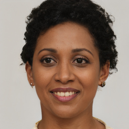 Joyful latino young-adult female with short  black hair and brown eyes
