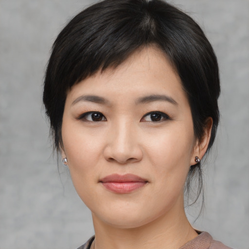 Joyful asian young-adult female with medium  black hair and brown eyes