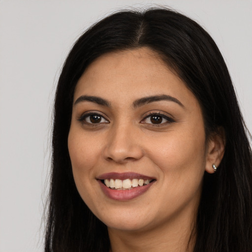 Joyful latino young-adult female with long  black hair and brown eyes