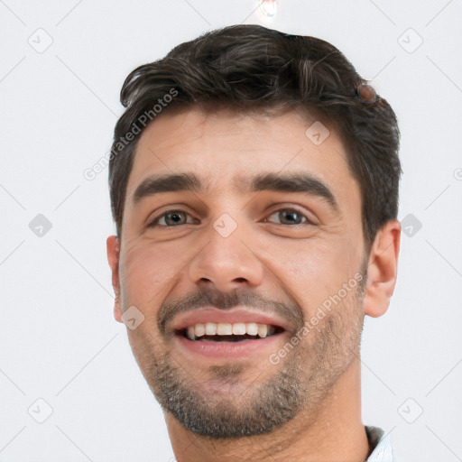 Joyful white young-adult male with short  black hair and brown eyes