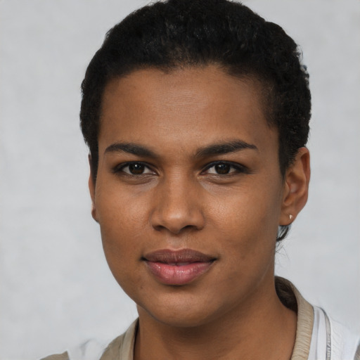 Joyful black young-adult female with short  black hair and brown eyes