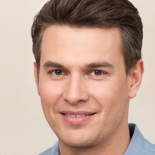 Joyful white young-adult male with short  brown hair and grey eyes