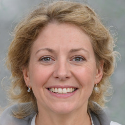 Joyful white adult female with medium  brown hair and blue eyes