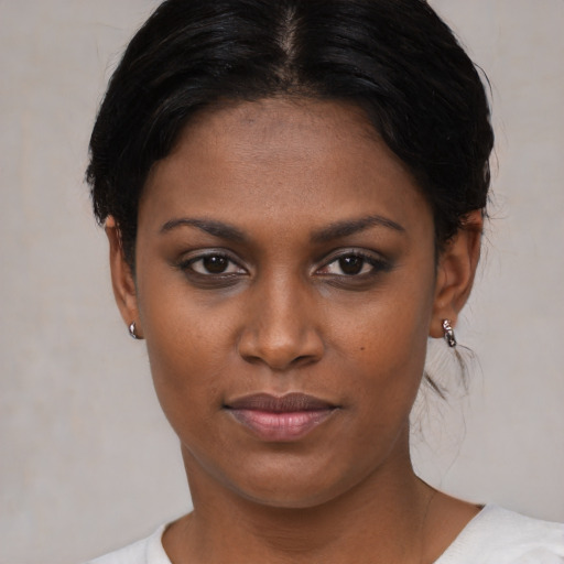 Joyful black young-adult female with short  black hair and brown eyes