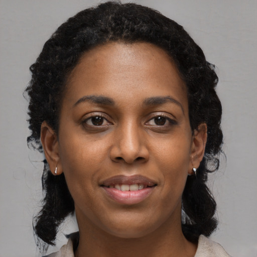 Joyful black young-adult female with medium  black hair and brown eyes