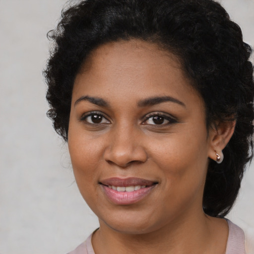 Joyful black young-adult female with long  brown hair and brown eyes