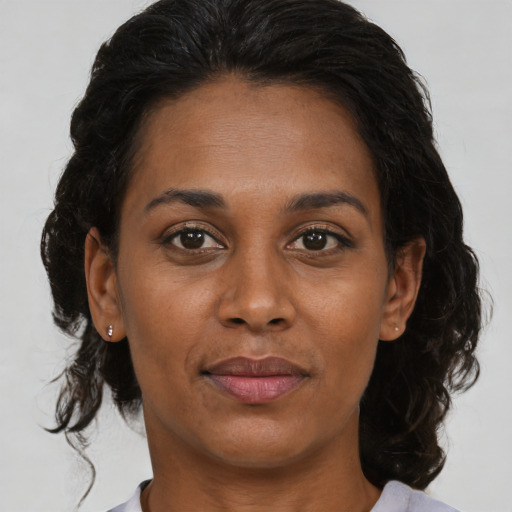 Joyful black adult female with medium  brown hair and brown eyes