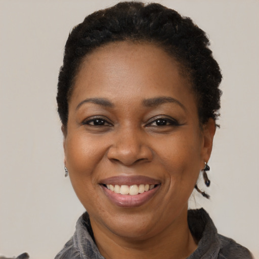 Joyful black adult female with short  black hair and brown eyes