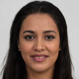 Joyful latino young-adult female with long  brown hair and brown eyes