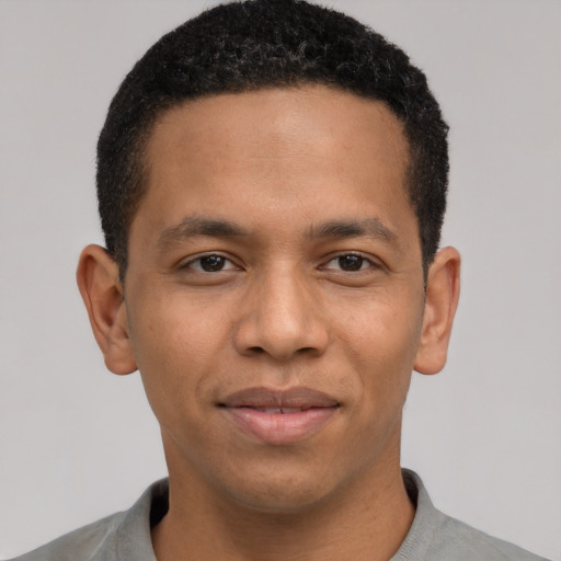 Joyful latino young-adult male with short  brown hair and brown eyes