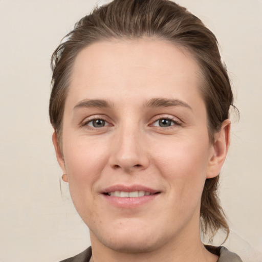 Joyful white young-adult female with medium  brown hair and grey eyes