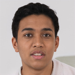 Joyful latino young-adult male with short  brown hair and brown eyes