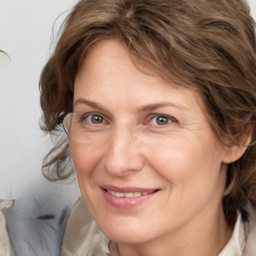 Joyful white adult female with medium  brown hair and grey eyes