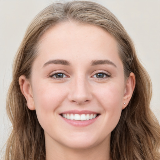 Joyful white young-adult female with long  brown hair and blue eyes