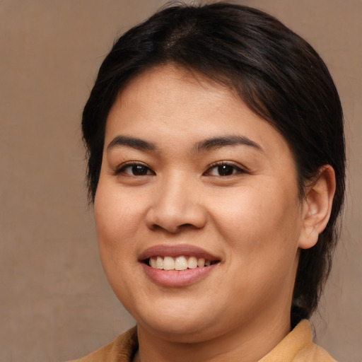 Joyful asian young-adult female with medium  brown hair and brown eyes