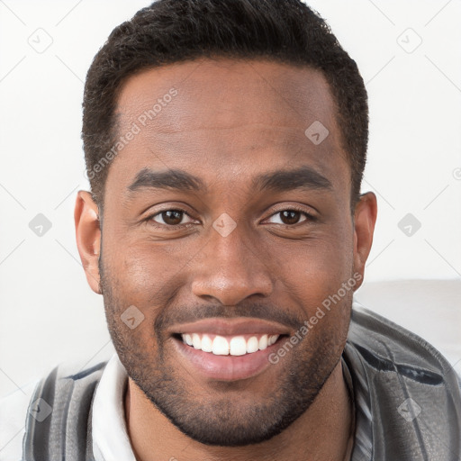 Joyful black young-adult male with short  brown hair and brown eyes