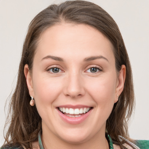 Joyful white young-adult female with medium  brown hair and grey eyes