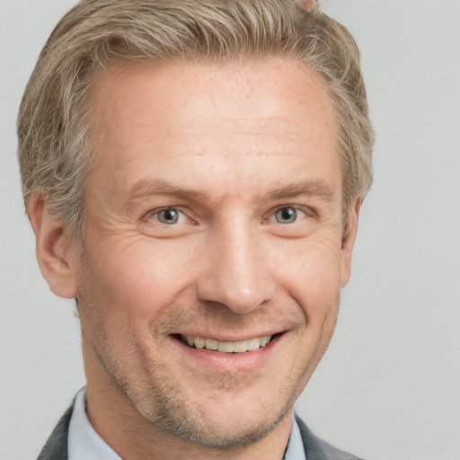 Joyful white adult male with short  brown hair and grey eyes