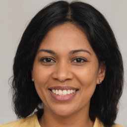 Joyful latino young-adult female with medium  brown hair and brown eyes