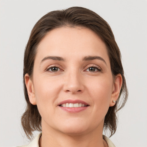 Joyful white young-adult female with medium  brown hair and grey eyes