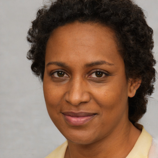 Joyful black adult female with short  brown hair and brown eyes