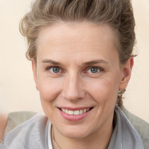 Joyful white adult female with medium  brown hair and blue eyes