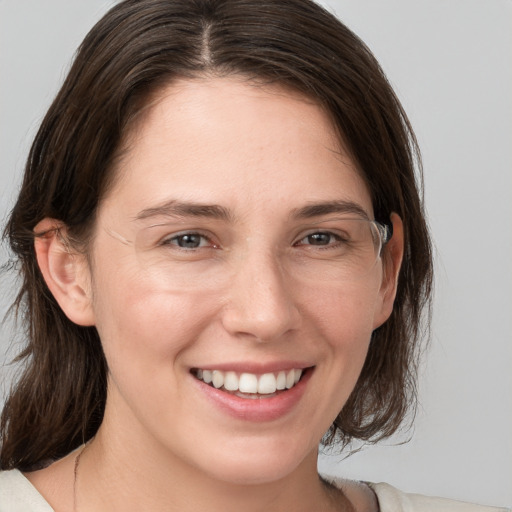 Joyful white young-adult female with medium  brown hair and grey eyes