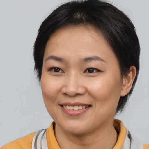 Joyful asian adult female with medium  brown hair and brown eyes